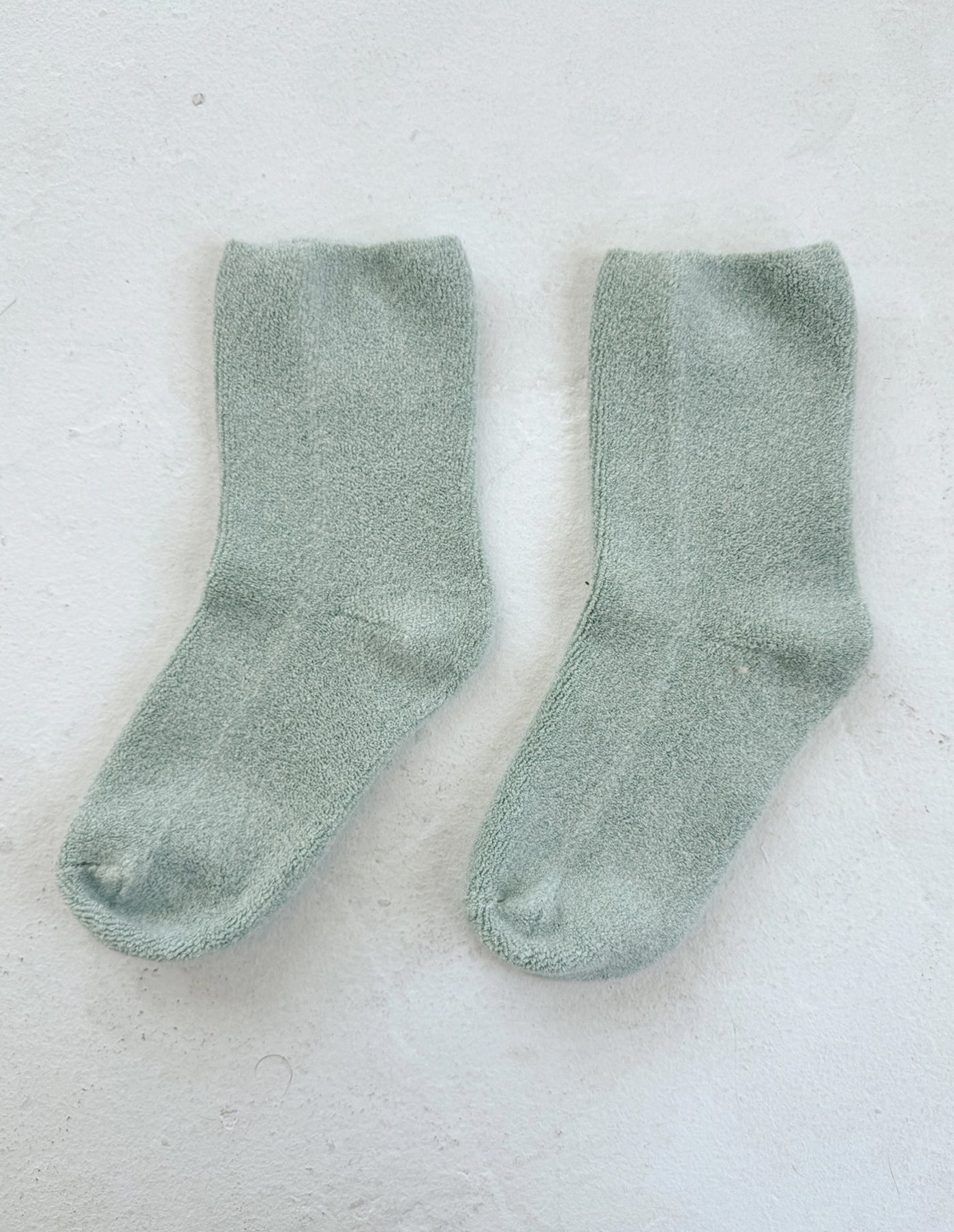 Pair of green socks on a light gray background