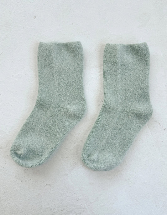 Pair of green socks on a light gray background