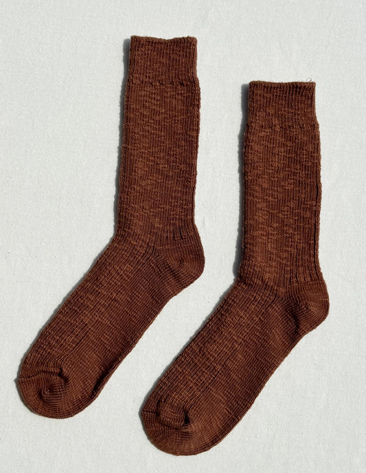 Pair of brown socks on a light gray background