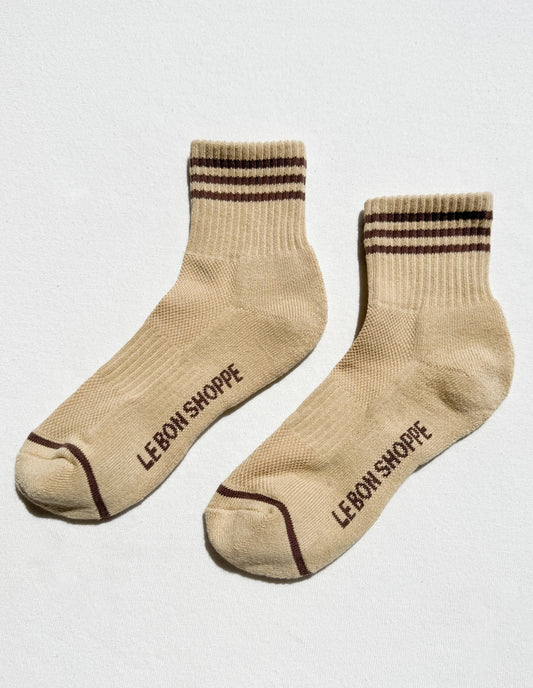 Pair of beige socks with brown accents and 'LEBON SHOPPE' branding on a light gray background
