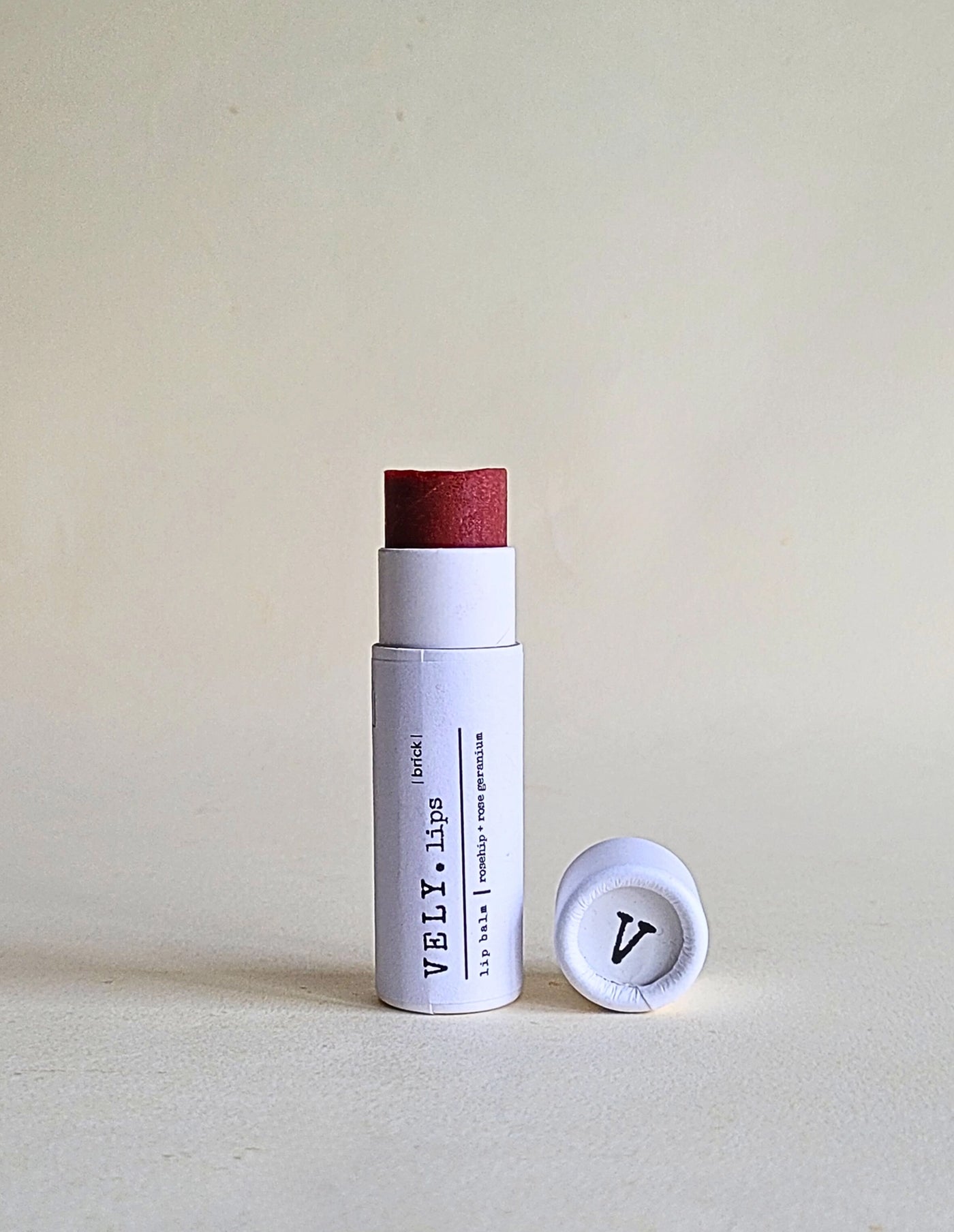 White cylindrical container with red cap and visible branding on a light gray background