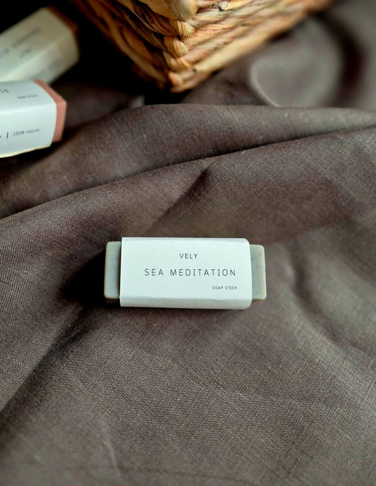 Bar of soap labeled 'Vely Sea Meditation' on a textured fabric surface
