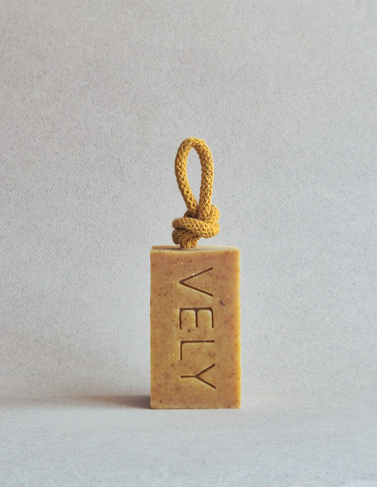 Rectangular bar of soap with a rope on a light gray background