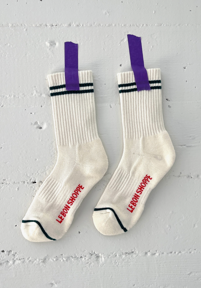 White socks with black stripes and red text on a light gray background